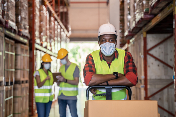a man working in a warehouse with a mask