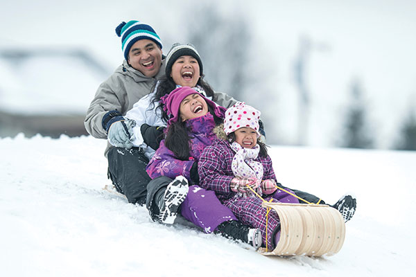 family sledding together