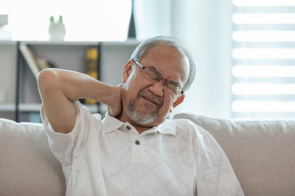 an elderly man experiencing neck pain