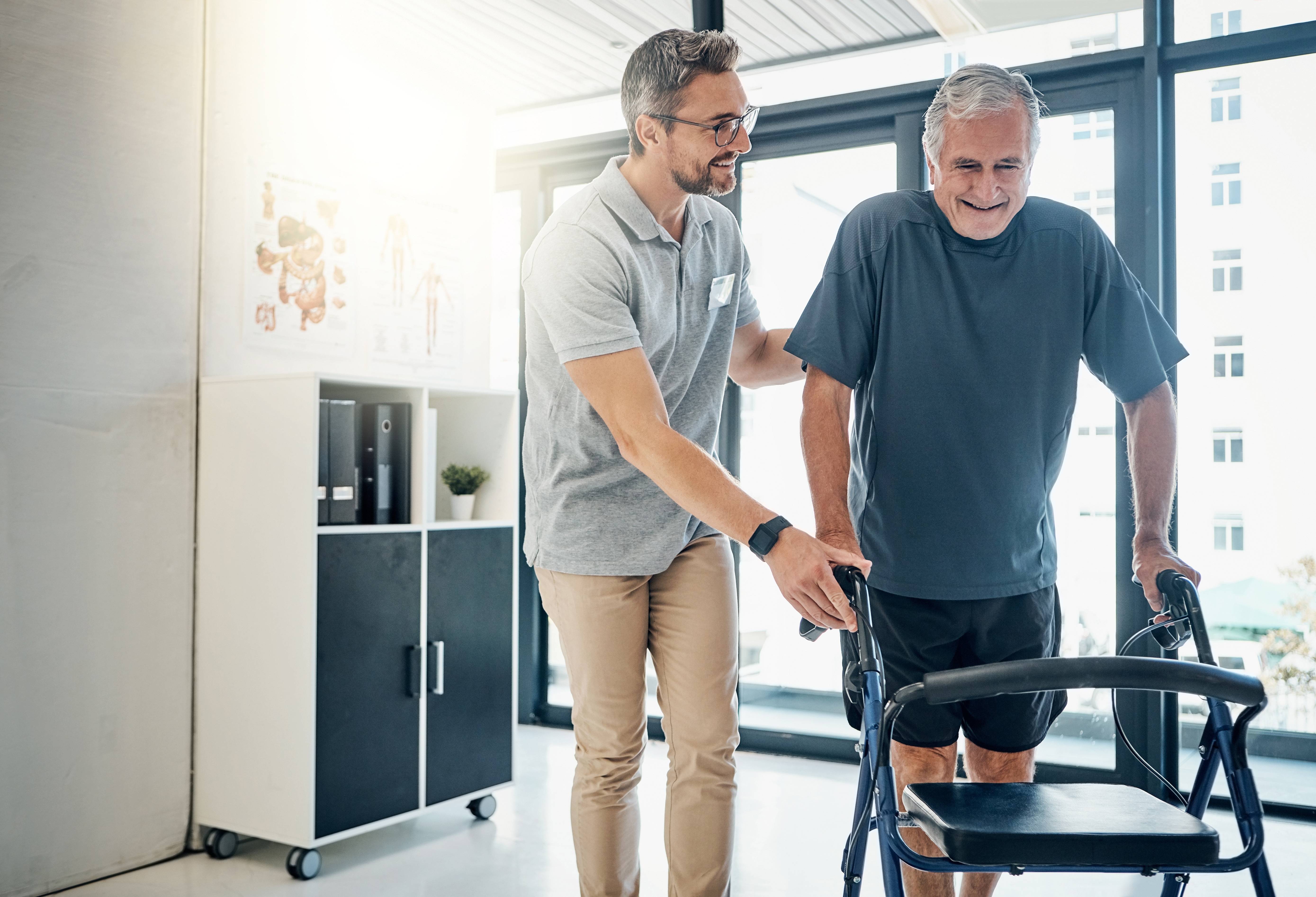 Physiotherapist supporting patient with Parkinson's disease with walking exercise